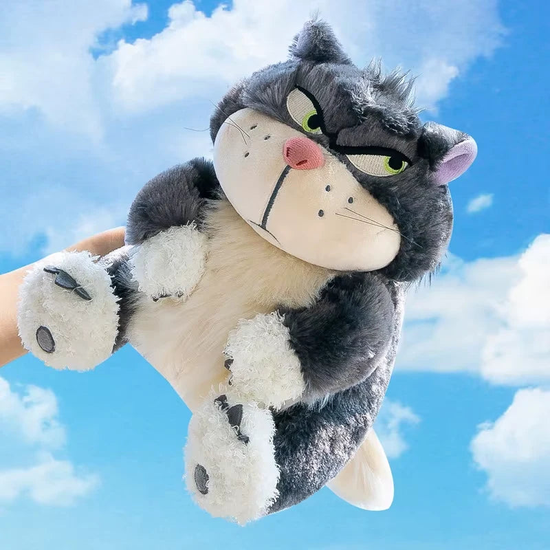 alt="Lucifer Bad Cat Plush Toy with grumpy face, soft black and white fur, and pink ears sitting on a couch – funny and collectible plushie"