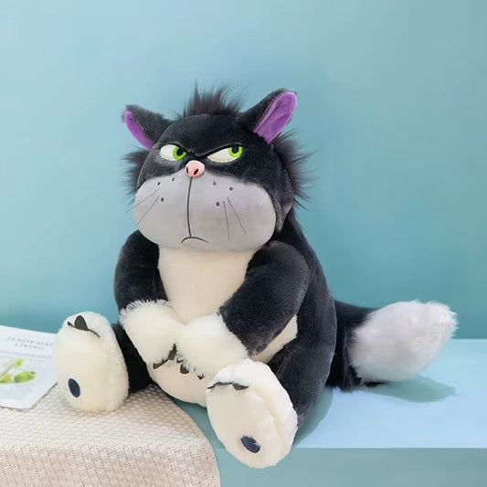 alt="Lucifer Bad Cat Plush Toy with grumpy face, soft black and white fur, and pink ears sitting on a couch – funny and collectible plushie"