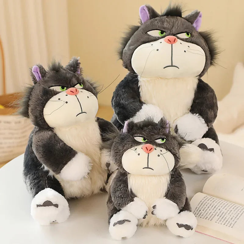 Lucifer Bad Cat Plush Toy with grumpy face, soft black and white fur, and pink ears sitting on a couch – funny and collectible plushie