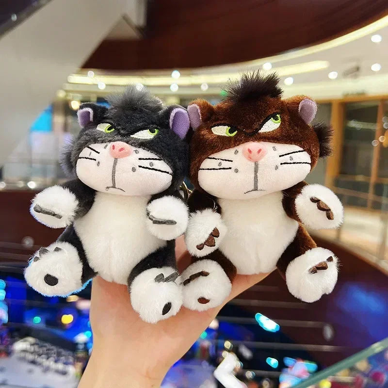 Hand holding multiple Mr. Grumps plush keychains in indoor mall